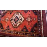 A North West Persian Tafresh rug, central diamond medallion on a rouge field within stylised