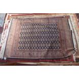 A Bokhara style carpet, with elephant pad motifs, on a blue ground, contained by geometric