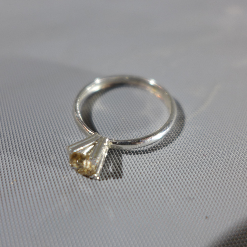 A white metal solitaire diamond ring, the round cut diamond approx. .45cts, tests as gold