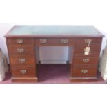 An Edwardian mahogany desk, with leather top, nine drawers, raised on stepped base, H.77 W.134 D.