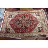 A Heriz style carpet, with central geometric medallion, on a red ground, contained by geometric