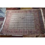 A Bokhara style carpet, with elephant pad motifs on a beige ground, contained by geometric border,