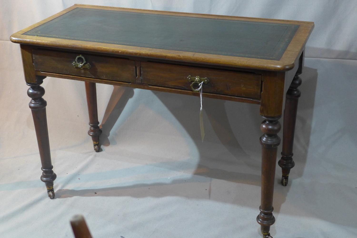 An early 20th century mahogany writing table, with two drawers, leather top, raised on turned legs