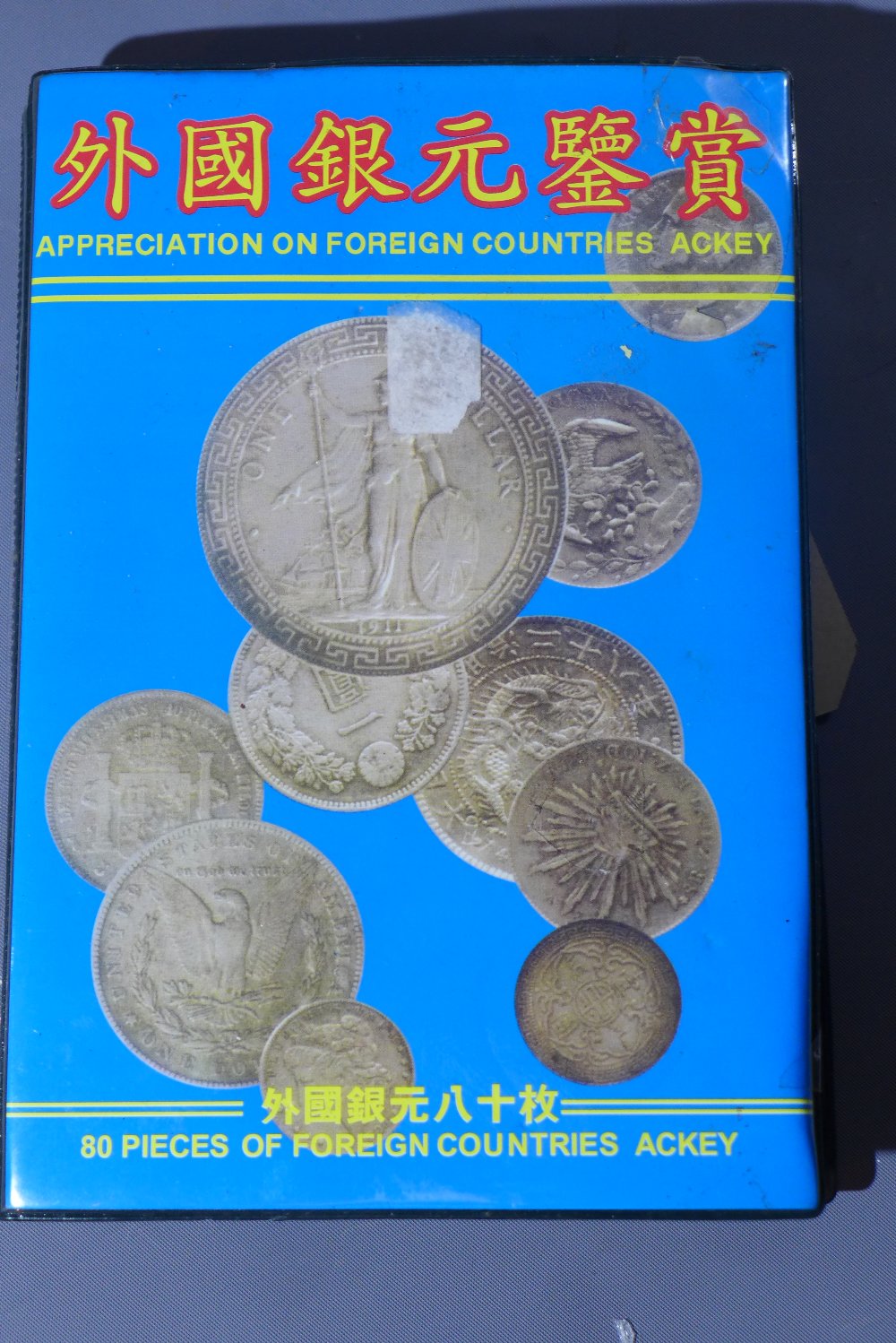 A collection of 80 foreign coins in display folder, including USA, New Zealand, Philippines and