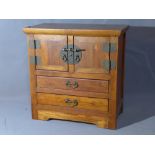 A 20th century Chinese hardwood miniature cabinet, with two doors over two drawers, raised on