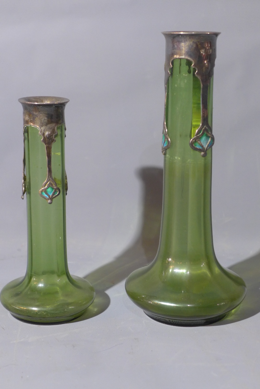 A pair of Art Nouveau Kate Harris green glass tulip vases, having silver collars