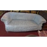 An early 20th Chesterfield sofa, with cream linen upholstery, having blue damask cover, raised on