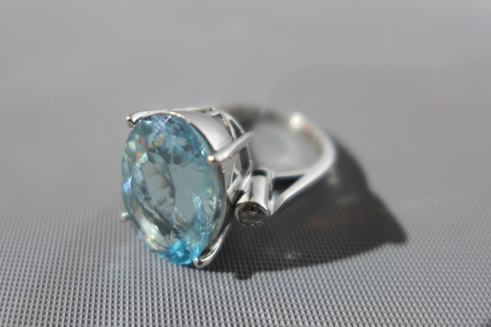 An 18ct white gold, diamond and aquamarine ring, the central oval cut aquamarine approx. 8.85cts,