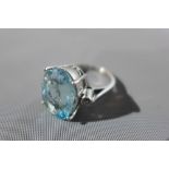 An 18ct white gold, diamond and aquamarine ring, the central oval cut aquamarine approx. 8.85cts,