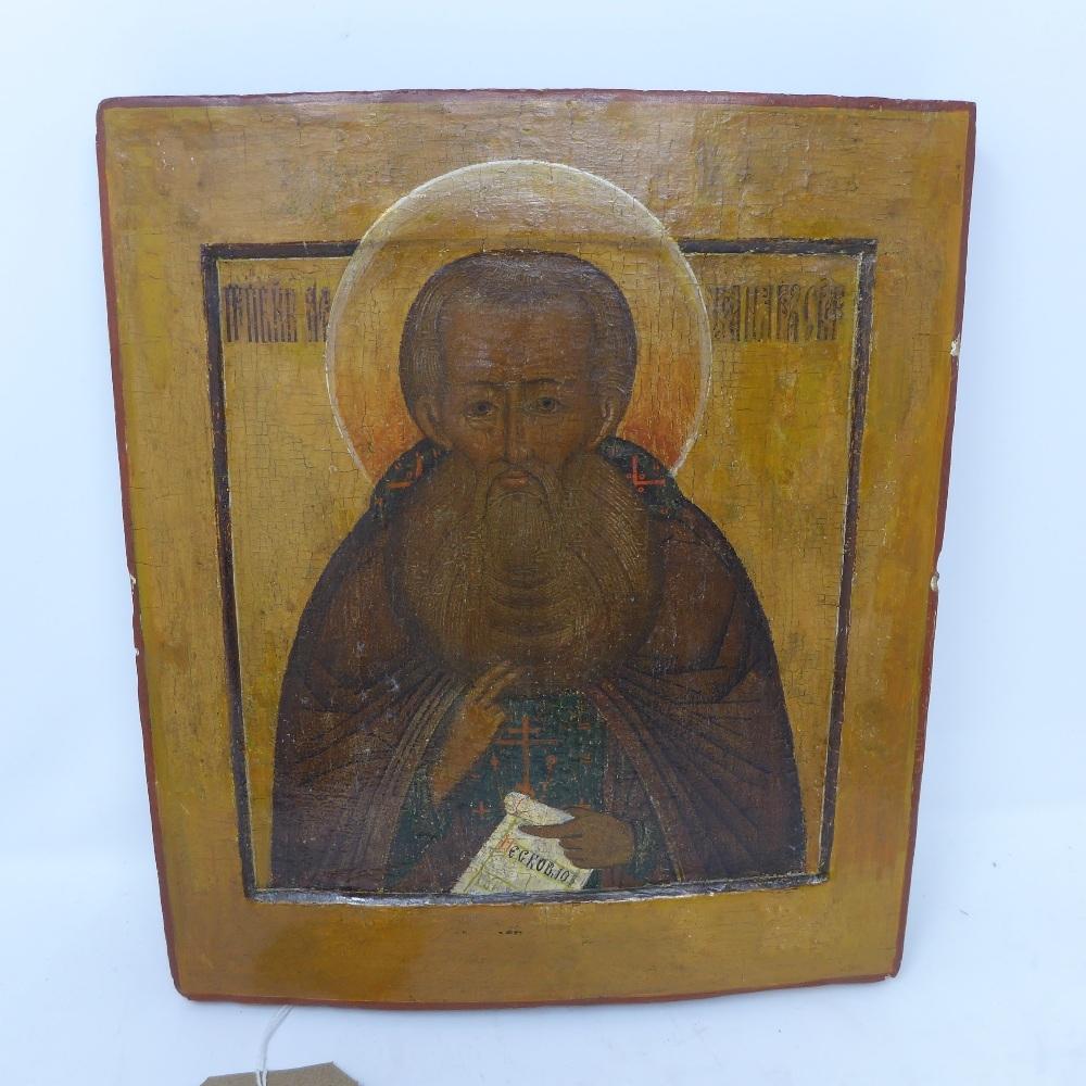 A Russian icon depicting a Saint shown in profile half-length, blessing and holding a scroll of