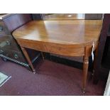 A 19th century mahogany fold over tea table with box wood inlay, raised on turned legs and castors