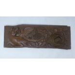 A 17th century carved oak wall plaque depicting a dragon, H.60cm W.21cm