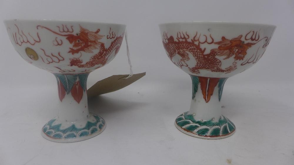 A pair of Chinese Republican period porcelain stem cups, c.1920, hand painted with dragons chasing