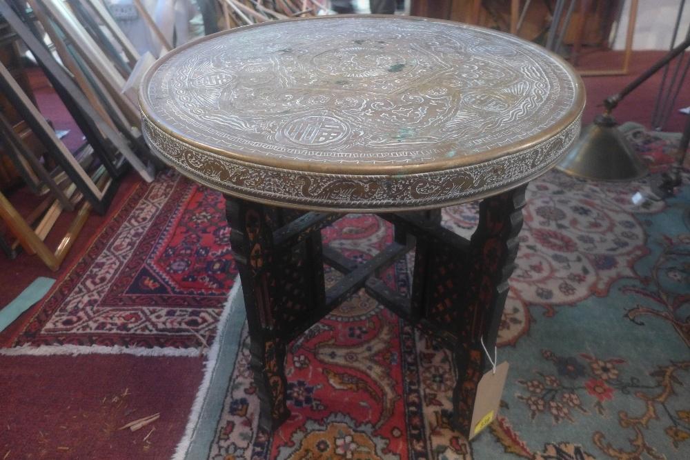 An late 19th/early 20th century Chinese nomads table with brass top depicting character marks, D.