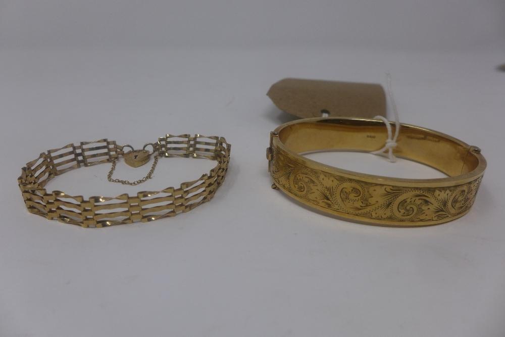 A vintage yellow 9ct gold bangle having engraved design and a 9ct gold four bar gate bracelet with