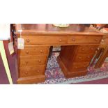 A 19th century pitch pine pedestal desk, having brown leather skiver, with two long over six small