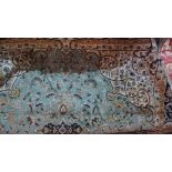 A Kashan style carpet, with central floral medallion on a green ground, contained by floral borders,