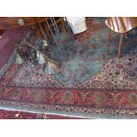 A Pakistani carpet, with central floral medallion on a green ground, within floral borders on a