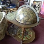 A vintage globe drinks trolley, with under tier shelf raised on casters