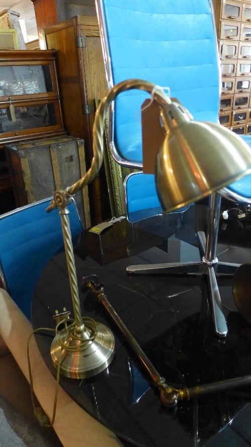 A contemporary brass adjustable desk lamp