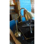 A contemporary brass adjustable desk lamp
