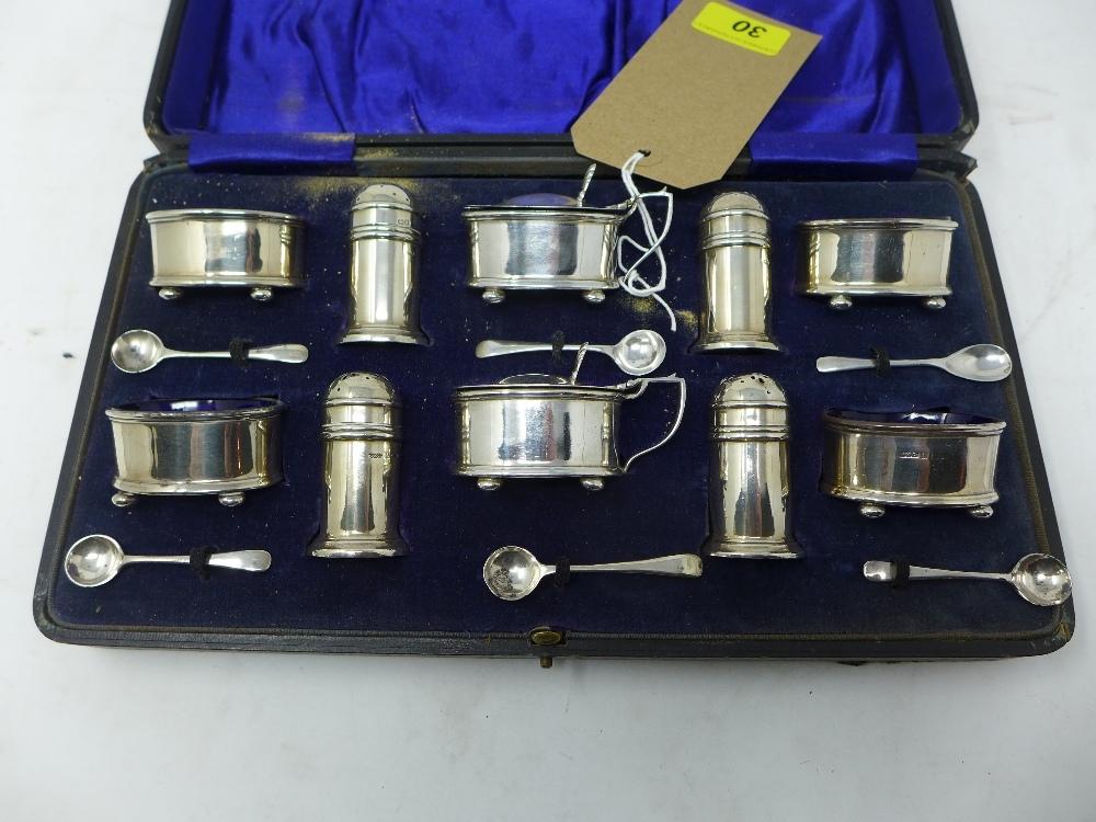 A cased set of early 20th century silver salts and pepperettes with blue glass liners, hallmarked