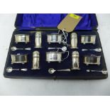 A cased set of early 20th century silver salts and pepperettes with blue glass liners, hallmarked