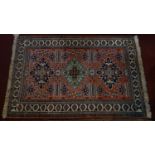 A Turkish part silk rug, with triple geometric medallion on a salmon pink ground, contained by