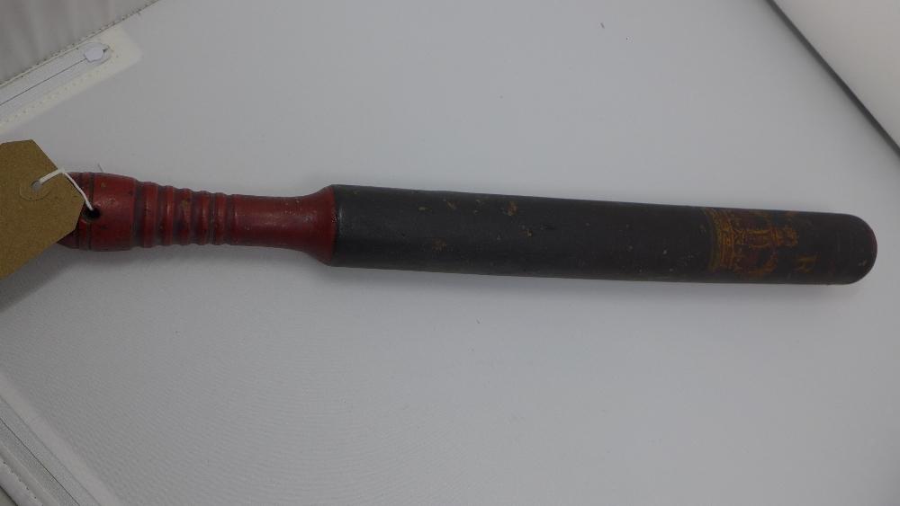 A Victorian ebonised police truncheon, with red painted handle, bears crown and V.R., H.47cm