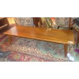 A mid 20th century walnut coffee table, raised on splayed legs, H.30 W.139 D.47cm