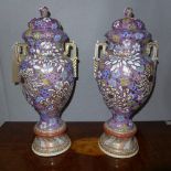 Two Satsuma style twin handled vases with covers, polychrome painted with flowers on a purple