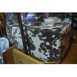 A contemporary footstool upholstered in faux cow hide, H.39cm L.99cm W.51cm