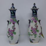 A pair of Losol ware porcelain vases and covers, with twin scroll handles, decorated with parrots on