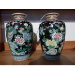 A pair of Chinese vases, polychrome decorated with phoenixes and flowers on a black ground, both