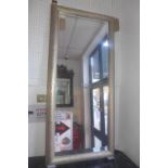 A large contemporary wall mirror, the rectangular bevelled plate within a textured silvered frame,
