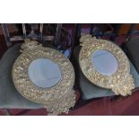 A pair of Art Nouveau heavy brass mirrors, with embossed decoration, circular bevelled plate, 53 x