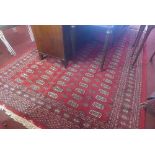 A Bokhara carpet with elephant pad motifs on a red ground, contained by geometric borders, 267 x