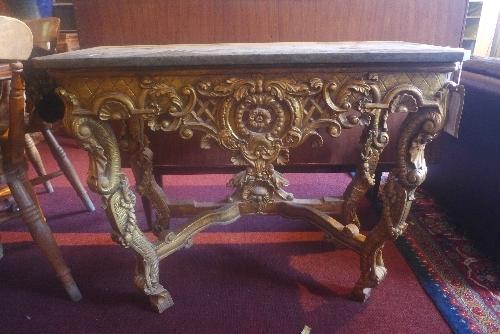 A mid 20th century Rococo style giltwood console table, having marble top on carved C-scroll legs