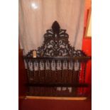 A 20th Century Portuguese headboard, in ornately carved wood with pierced decoration, H.150cm W.