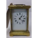 A polished brass carriage clock, with a white enamel dial with Roman numerals, H.11cm