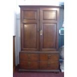 An early 19th century oak housekeepers cupboard, with two doors enclosing adjustable shelves,