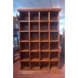 A hardwood pigeon hole cabinet, the moulded cornice above 24 pigeon holes, on stepped pedestal base,