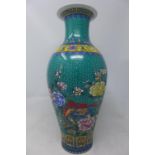 A Chinese porcelain vase, decorated with flora and fauna on a green ground, bearing character