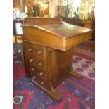 An early 20th Century walnut and marquetry inlaid davenport, with four drawers opposing dummy