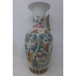 A Chinese porcelain famille rose vase, decorated with figures in a courtyard scene, bearing