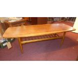 A mid 20th century teak coffee table, with rail under tier, on tapered legs, H.48 W.135 D.48cm