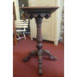 An early 20th Century oak jardinere stand, with a square top raised on an ornately carved quadraform
