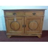 A 'this and that' light oak sideboard, with two drawers over two cupboard doors raised on bracket