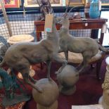 Two cast iron deer standing on balls, on stepped circular bases, H.99cm (2)