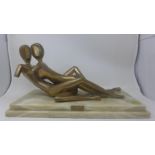 A signed bronze sculpture of reclining nudes, titled 'Embrace', by John Mulvey, 1972, raised on a